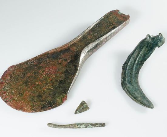 : A collection of Bronze Age objects found at the site, including the axe, dress pin, and sickle