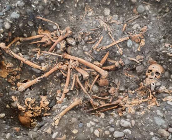 Multiple individuals buried in a pit by the gallows. 