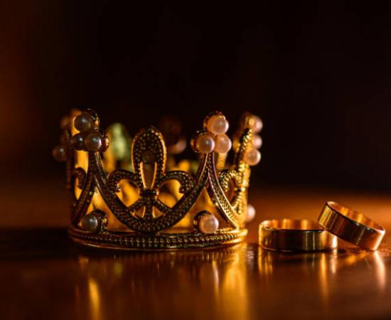 A bejewelled crown and rings, representative of gemstones showing power.