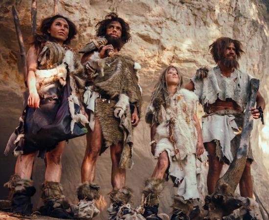 Tribe of four ancient humans wearing animal skin.  Source: Gorodenkoff/Adobe Stock